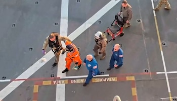 Miembro de la tripulación caminando con ayuda luego del amerizaje