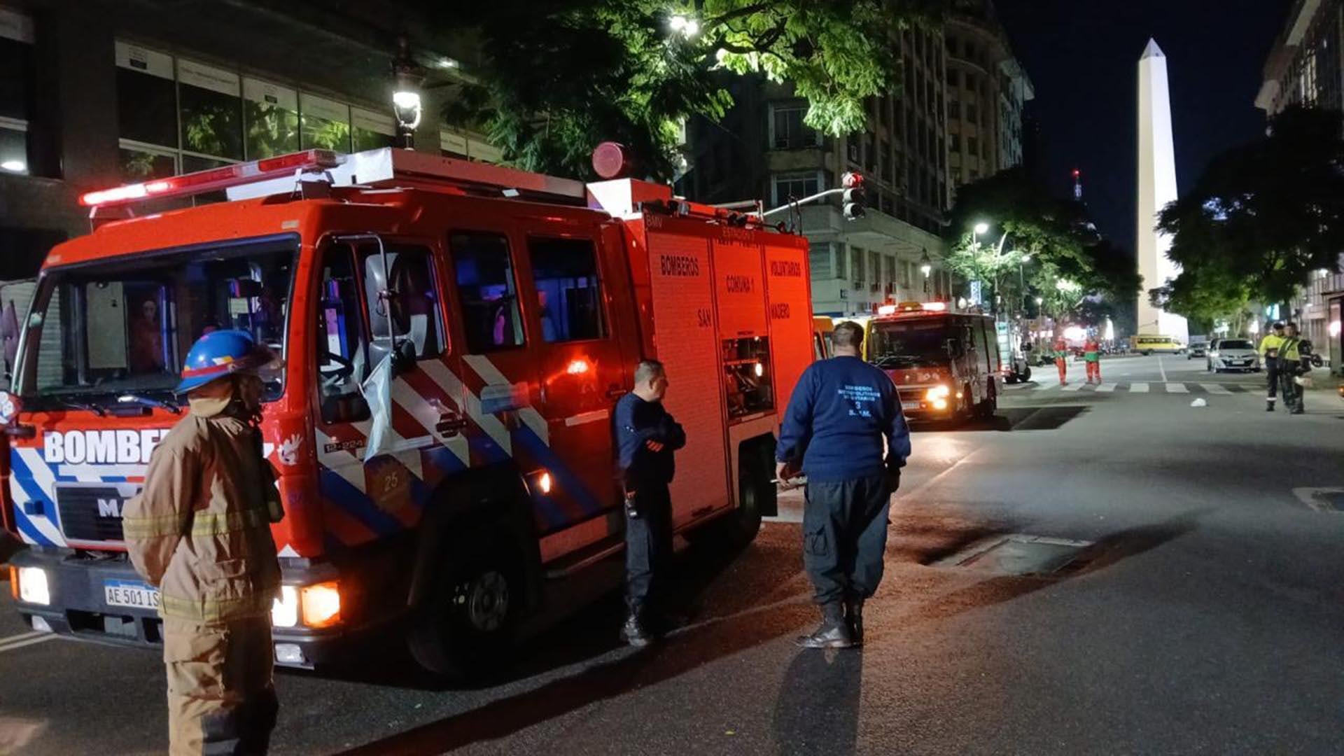 Bomberos trabajan en el lugar tras el incendio reportado en un hotel de Puerto Madero, con el Obelisco iluminado de fondo en la noche porteña.
