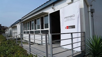 Módulos prefabricados de uso escolar con rampas de acceso y un banner con el logotipo del Pronied en el ingreso