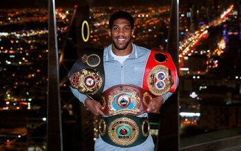 Anthony Joshua posa con cinturones