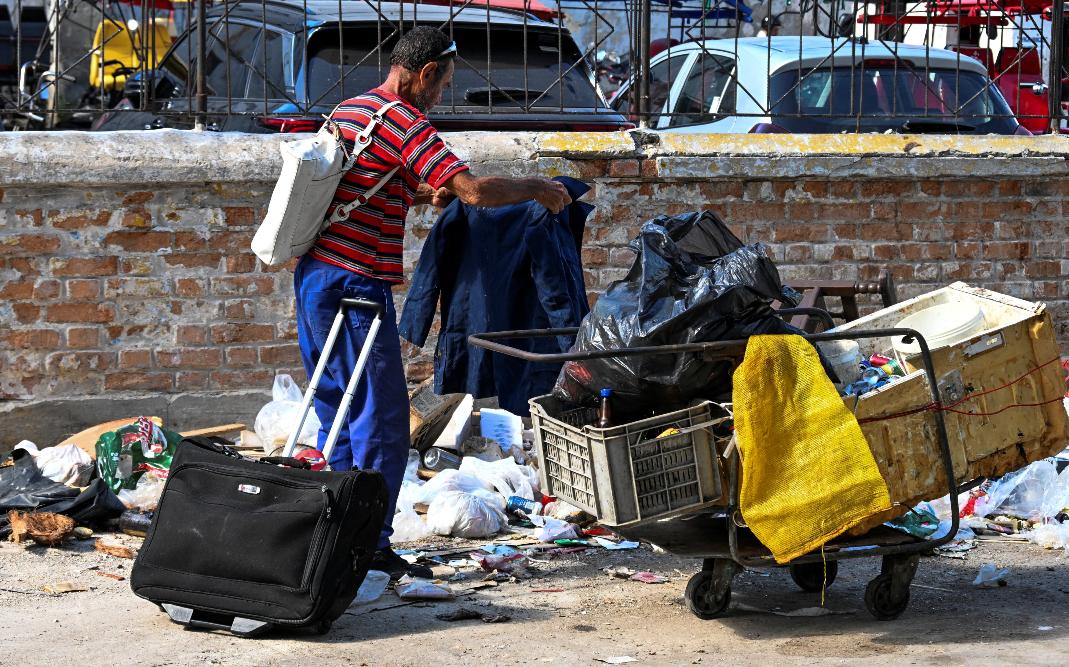 Un hombre recoge basura en una calle de La Habana, en medio del agravamiento de la pobreza durante la peor crisis económica que atraviesa Cuba en tres décadas, marcada por escasez de alimentos, medicinas y apagones diarios (Yamil LAGE / AFP)