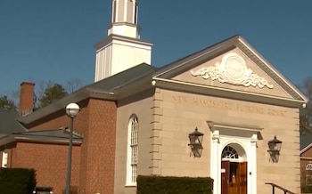Edificio de la Corte Suprema de New Hampshire con fachada de piedra y ladrillo, campanario blanco, ventanales, lámparas y un cartel que indica su nombre