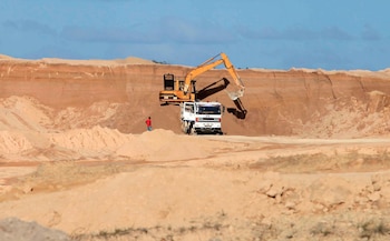 Una excavadora carga bauxita en un camión dentro de una mina de Bosai Minerals Group, en Linden, Guyana (REUTERS)