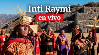 Hombre vestido como Inca con tocado dorado y traje rojo, rodeado de personas con atuendos andinos, con muros de piedra y montañas. Texto: Inti Raymi en vivo.