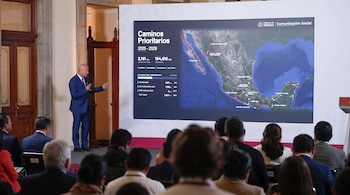 Un hombre en traje señala un mapa de México proyectado en una pantalla grande frente a un público sentado en un auditorio.