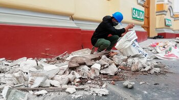 Un trabajador recoge escombros tras