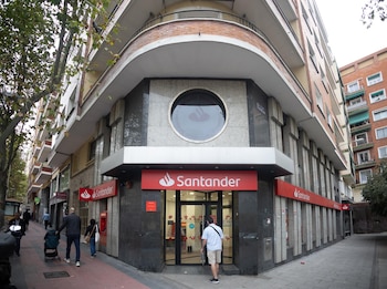 Un hombre entra a una oficina de Banco Santander.