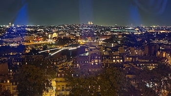 Vista nocturna panorámica de la ciudad de París con edificios iluminados y luces urbanas