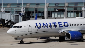 Avión Boeing 737 de United Airlines, blanco con motores azules, en una pista de aeropuerto junto a un puente de embarque con la etiqueta C23