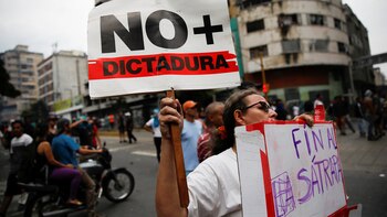 Una manifestante sostiene un cartel