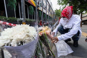 Un hombre coloca flores frente al bar musical donde el incendio provocó numerosas muertes en Bangkok (archivo/AP Foto/Wason Wanichakorn)
