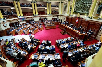 Vista panorámica del hemiciclo con legisladores en sus escaños, escritorios con computadoras y la bandera de Perú