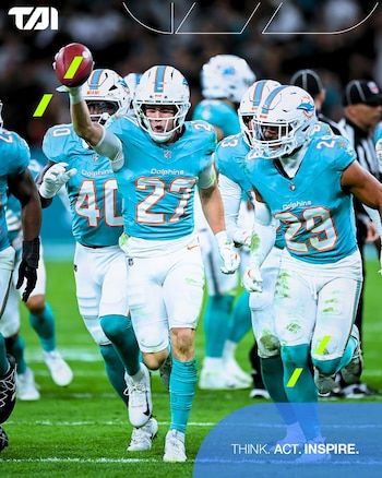 Jugadores de fútbol americano con uniforme turquesa de los Miami Dolphins celebran en el campo. El jugador del centro sostiene el balón en alto