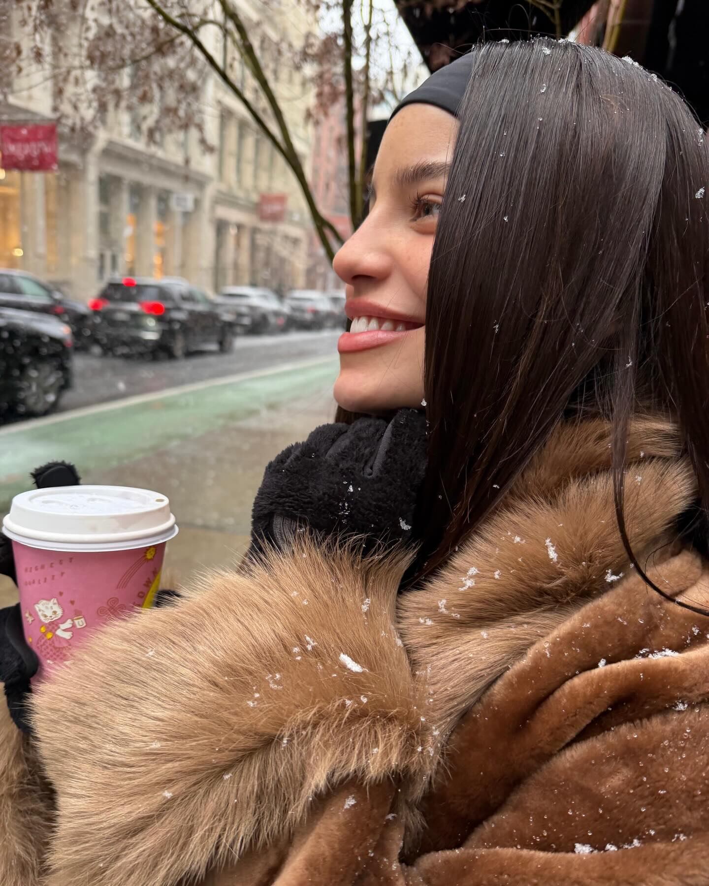 Emilia disfrutó de la nieve neoyorquina envuelta en un tapado de piel sintética y vaso térmico en mano