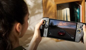 Una mujer sostiene una consola portátil Asus ROG Ally con la pantalla encendida frente a una estantería
