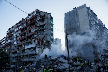 Los equipos de rescate retiran los escombros de una casa gravemente dañada tras un ataque ruso contra un barrio residencial en Kiev, Ucrania, el jueves 14 de mayo de 2026 (AP/Evgeniy Maloletka)