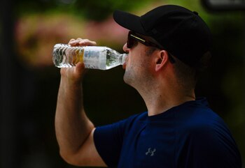 Un hombre bebe agua durante