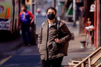 Una mujer con tapabocas mientras