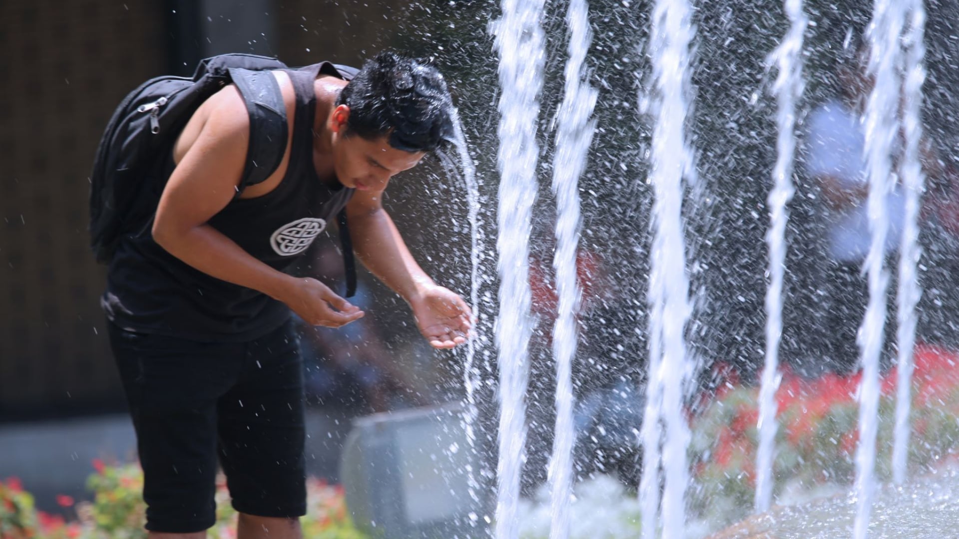 Un hombre se refresca en una fuente pública ante las altas temperaturas registradas en el Perú por el fenómeno El Niño. (Agencia Andina)