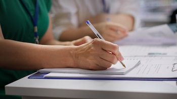 Una sanitaria rellenando un informe médico (Freepik)