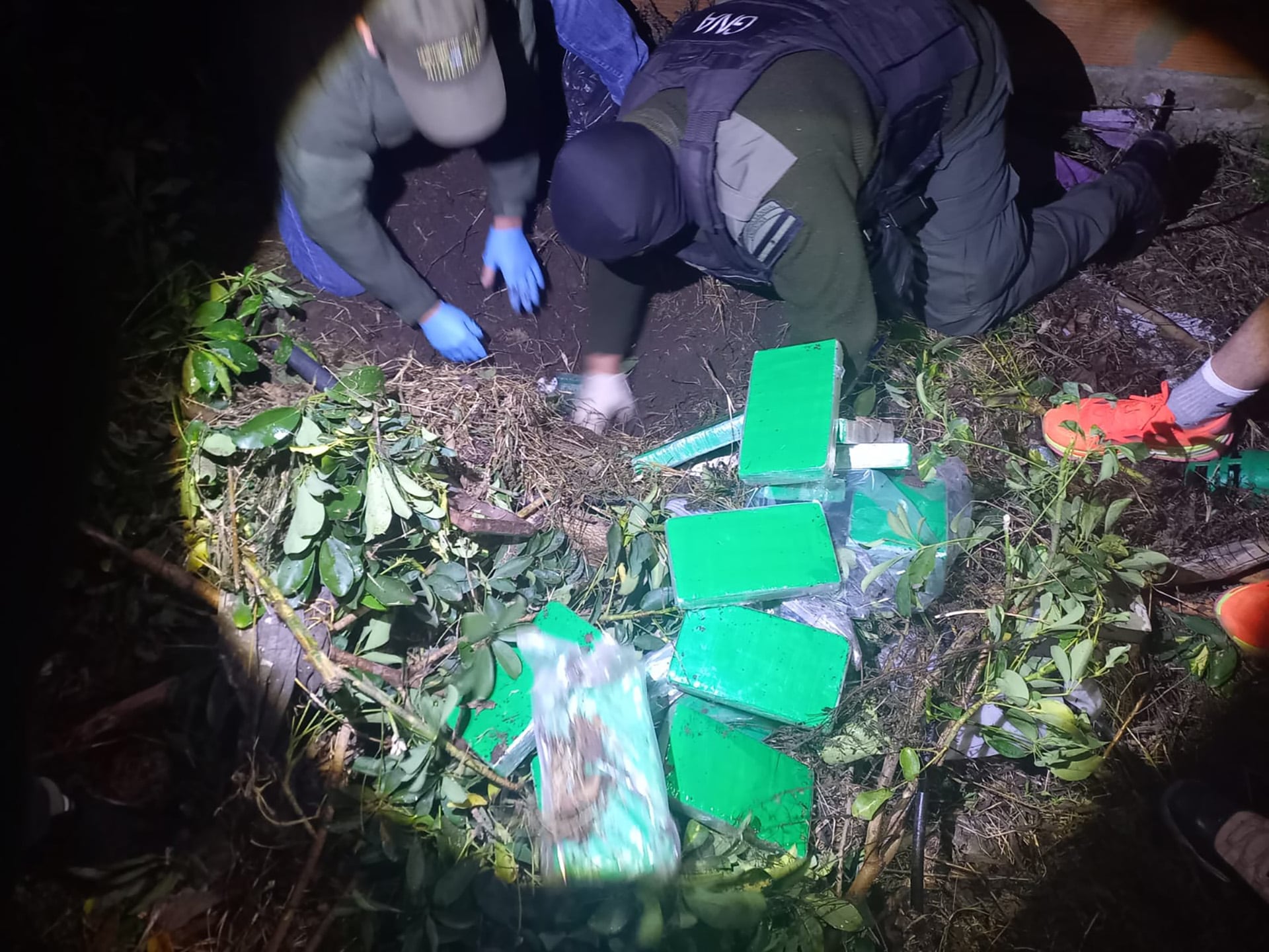 Miembros de la Gendarmería Nacional desentierran casi 60 kilogramos de cocaína encontrados en el patio de una vivienda particular en Santa Fe, Argentina, como parte de un operativo antidrogas.