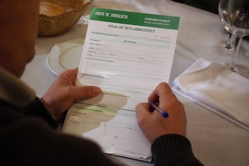 Un cliente de un restaurante cubriendo una hoja de reclamaciones (Imagen Ilustrativa Infobae)