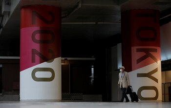 Un hombre con mascarilla pasa junto a los anuncios de los Juegos Olímpicos de Tokio 2020 en Tokio, Japón, el 7 de julio de 2021. REUTERS / Kim Kyung-Hoon