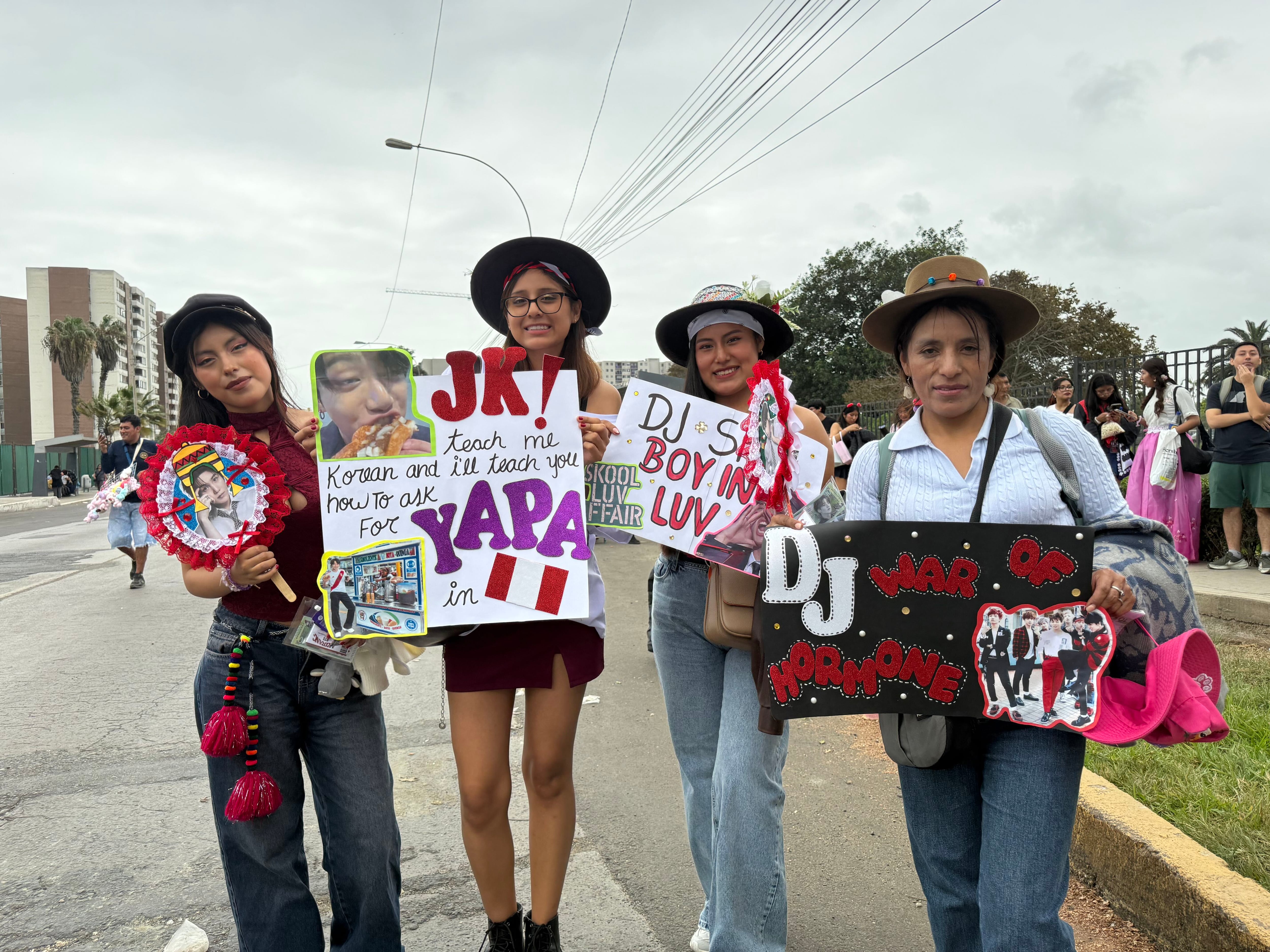 Varias seguidoras del grupo surcoreano BTS exhiben carteles hechos a mano en los exteriores del Estadio San Marcos previo a una presentación. (Infobae / Paula Díaz Elizalde)
