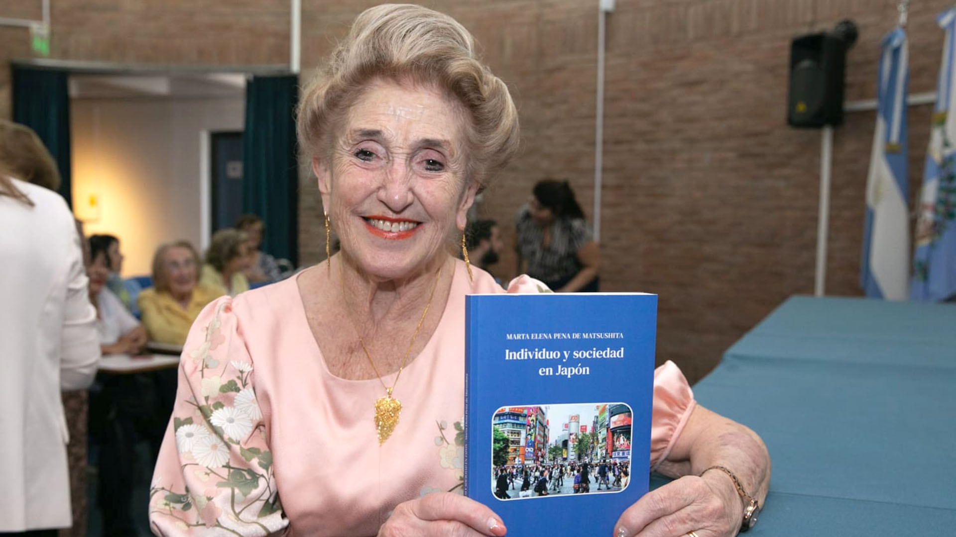 Marta Elena Peña de Matsushita sonríe mientras sostiene su libro