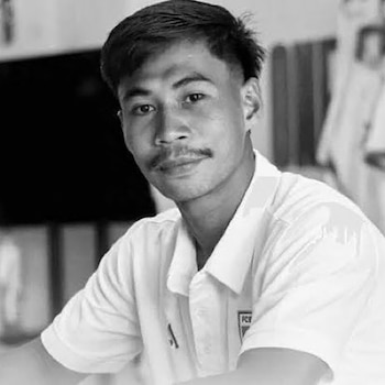 Hombre joven con bigote, cabello oscuro y camiseta blanca de cuello en retrato en blanco y negro. Fondo desenfocado