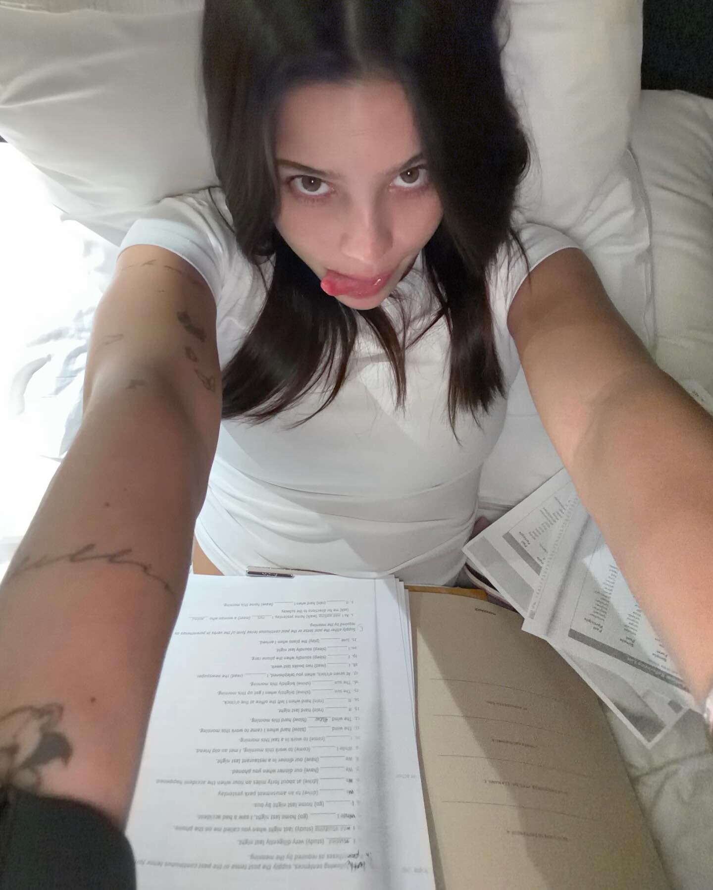 Emilia, en la intimidad de su rutina, posó recostada en la cama rodeada de carpetas y papeles de estudio