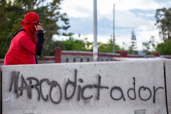 Un estudiante encapuchado descansa junto