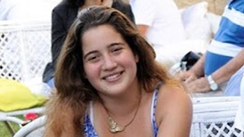 Retrato de una mujer joven de cabello castaño y largo, con blusa de tirantes azul y blanco, y un collar. Sonríe a la cámara