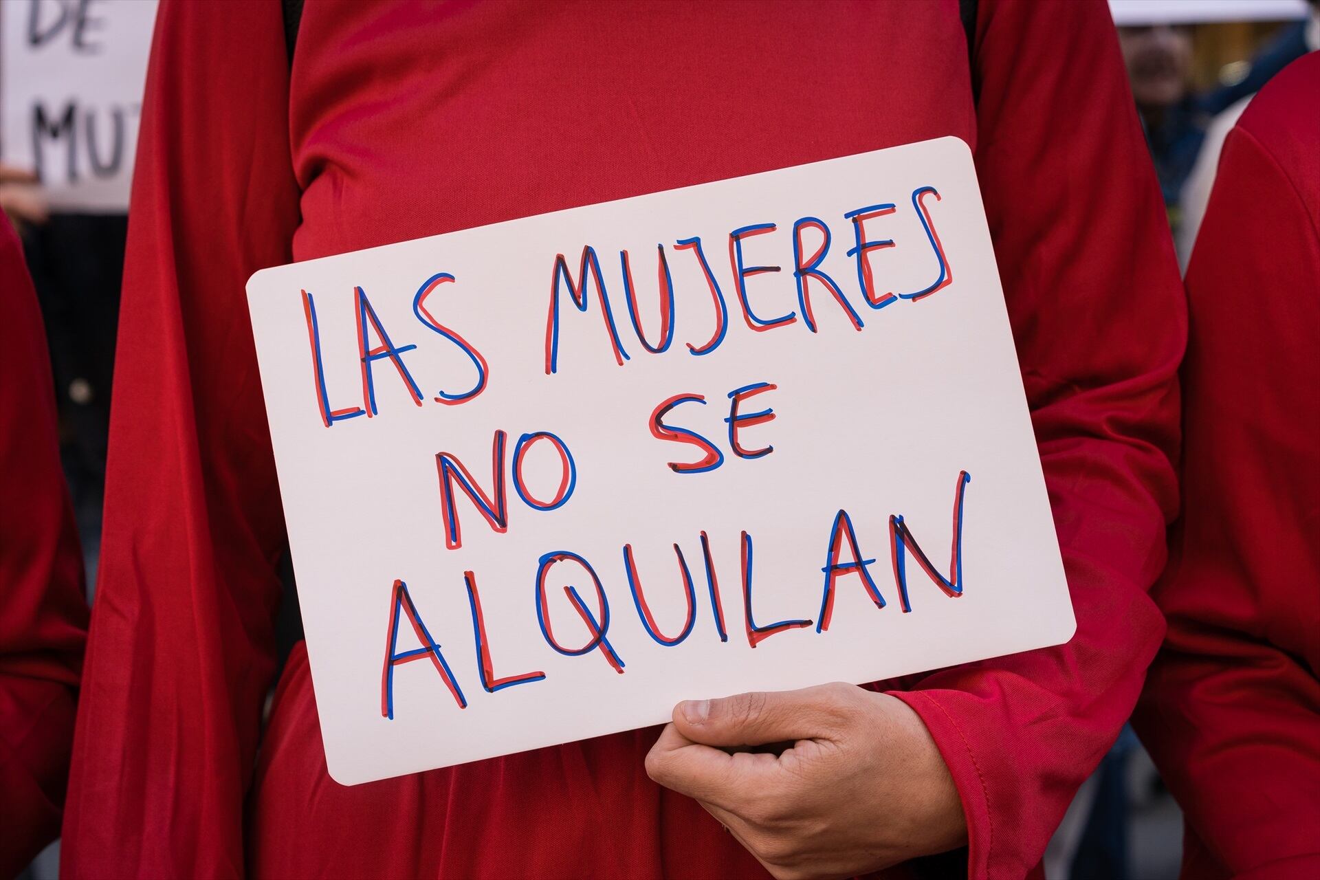 Una mujer con una pancarta que reza
