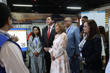 Un grupo de personas, incluyendo funcionarios, asiste a una presentación sobre el Plan Retorno al Hogar en Guatemala. Un orador explica en un monitor digital