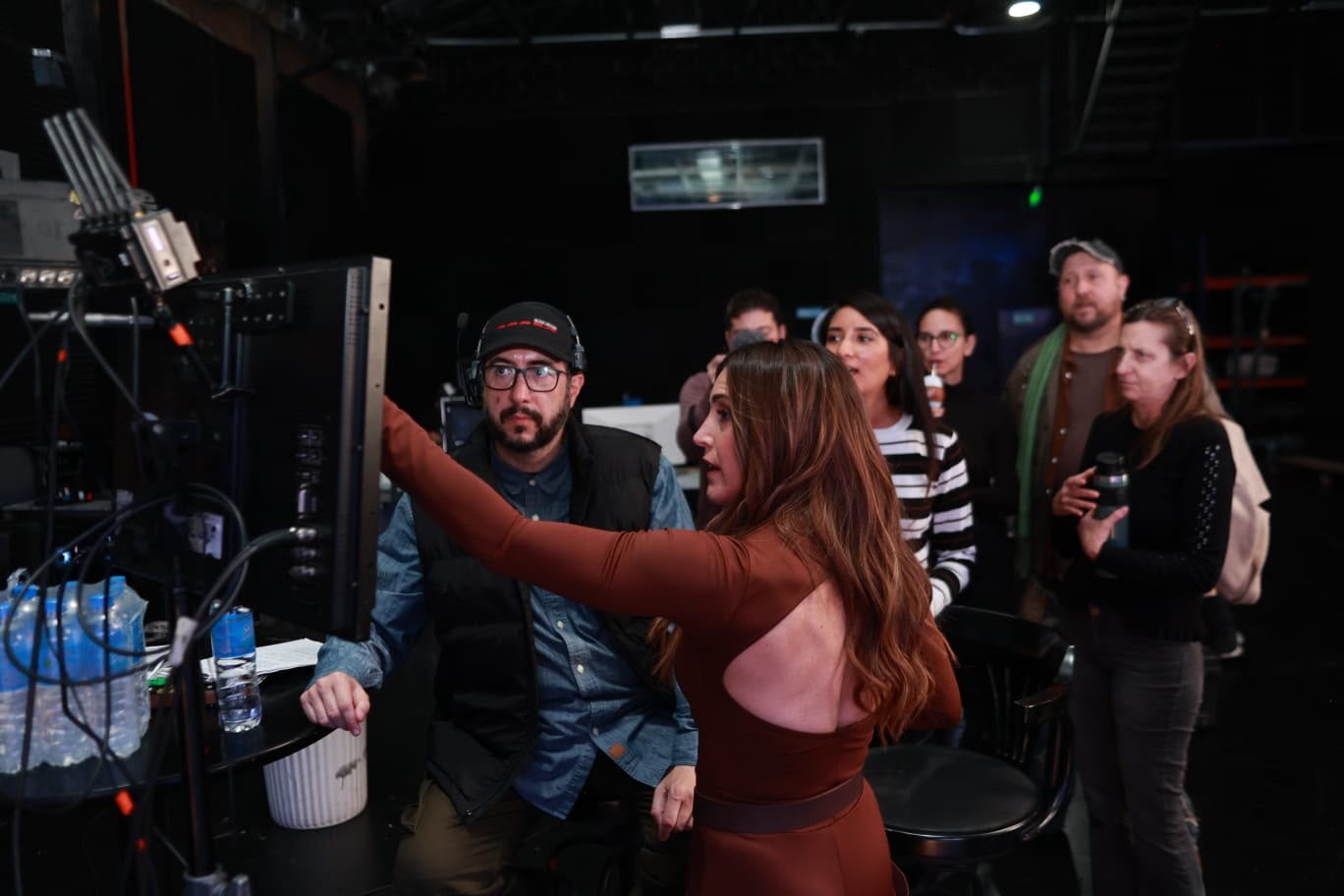 Soledad observa un monitor en la producción del tema 'Late el Sur' para los Juegos Suramericanos Santa Fe 2026, acompañada por miembros del equipo de trabajo