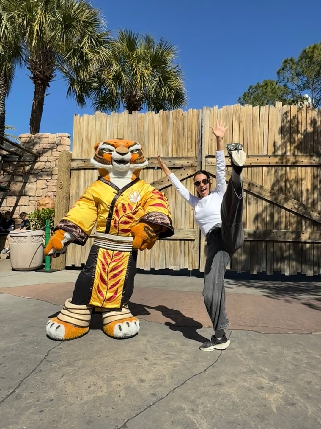 Pampita se divierte en grande durante su visita al parque de diversiones Universal en Estados Unidos, posando de manera acrobática con un personaje.