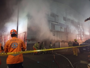 Las cuadrillas de emergencia desplegaron cintas de precaución y mangueras para ingresar a las áreas afectadas por el humo en Ciudad Arce.