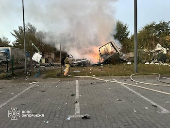 En esta fotografía facilitada por los servicios de emergencia de Ucrania el martes 6 de octubre de 2026, equipos de rescate extinguen el incendio de varios vehículos tras un ataque ruso contra una gasolinera en Zaporiyia, Ucrania. (Servicio de Emergencia de Ucrania vía AP)