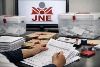 Manos manipulan actas electorales sobre una mesa con documentos, urnas transparentes y sobres lacrados, con el logo del JNE en una pantalla de fondo.
