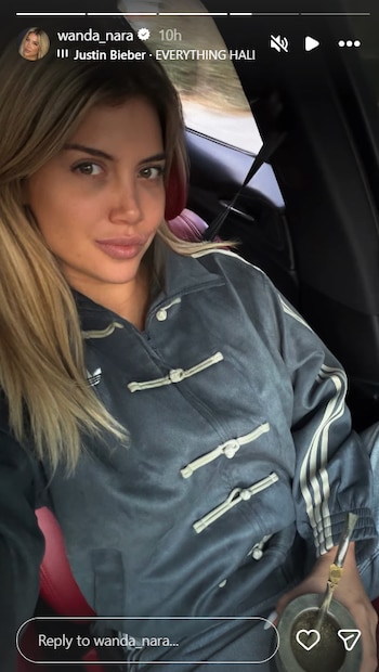 Wanda Nara, con cabello rubio, posa en el interior de un automóvil, sosteniendo un mate y vistiendo una chaqueta deportiva gris con detalles claros