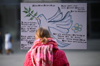 Una mujer mira un cartel en la instalación al aire libre a lo largo del camino del antiguo Muro de Berlín en el 35 aniversario de la caída del Muro en Berlín.