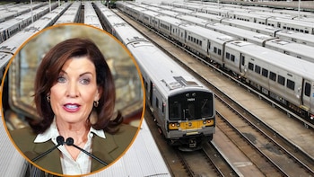 Un primer plano de Kathy Hochul se superpone a una vista aérea de un depósito con múltiples trenes de cercanías plateados estacionados en las vías