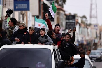 Un niño sostiene la bandera adoptada por los nuevos gobernantes sirios, mientras la gente celebra tras el derrocamiento de Bashar al-Assad, en Daraa. (REUTERS/Zohra Bensemra)