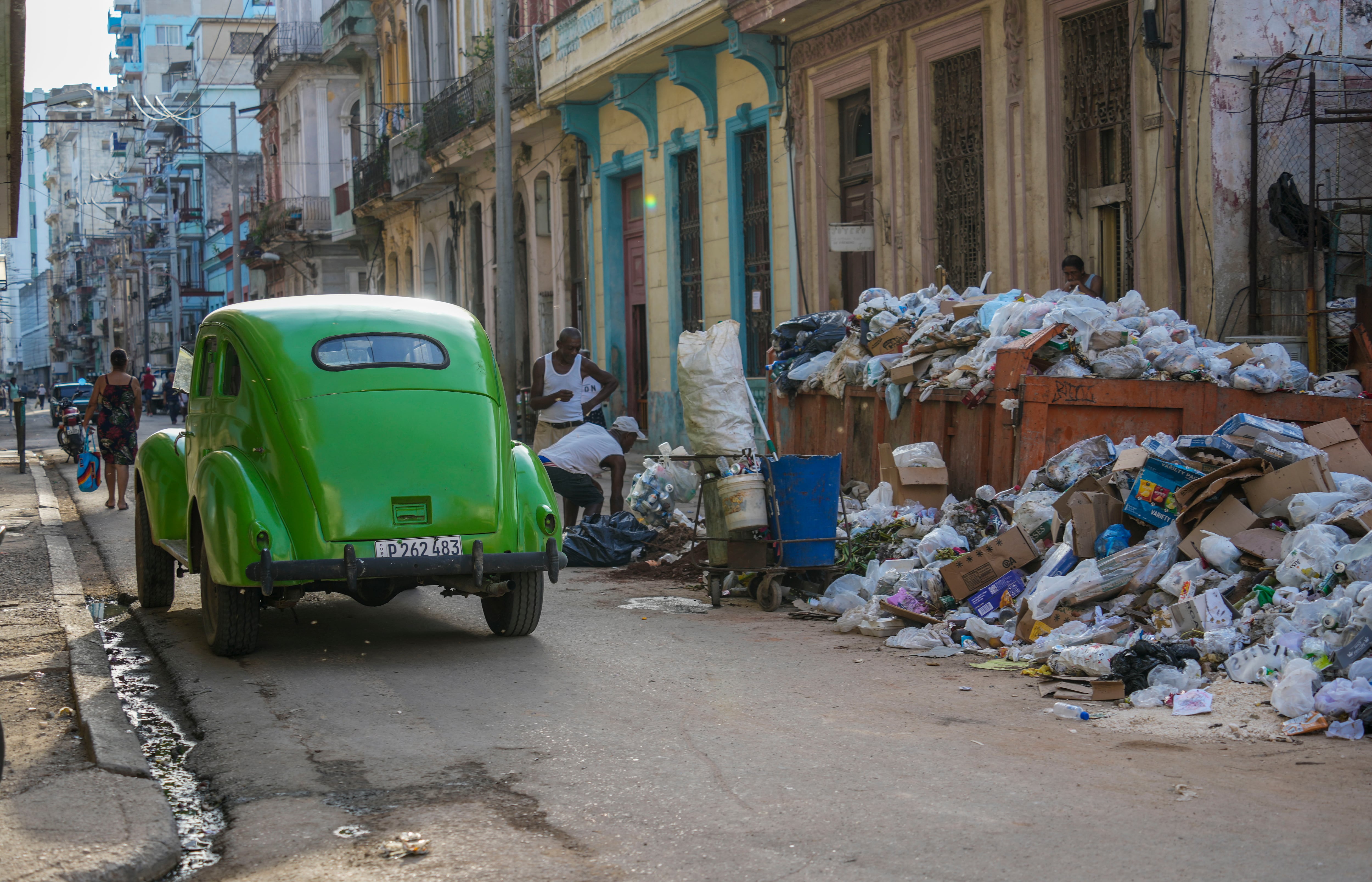 Un automóvil clásico pasa junto a basura acumulada en una calle de La Habana (Foto AP/Ramón Espinosa)