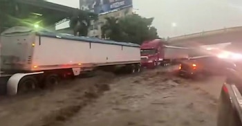 Peatones buscaron resguardarse mientras las lluvias azotaban San Pedro Sula. Las corrientes de agua arrastraron basura y escombros en varias calles. (Foto: Redes sociales / captura de video)