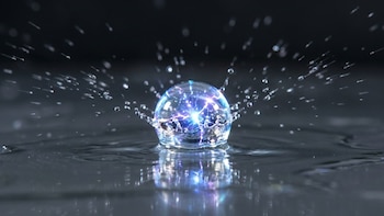 Primer plano de una gota de agua translúcida con destellos eléctricos azules y morados en su interior, salpicando microgotas sobre una superficie oscura y reflectante