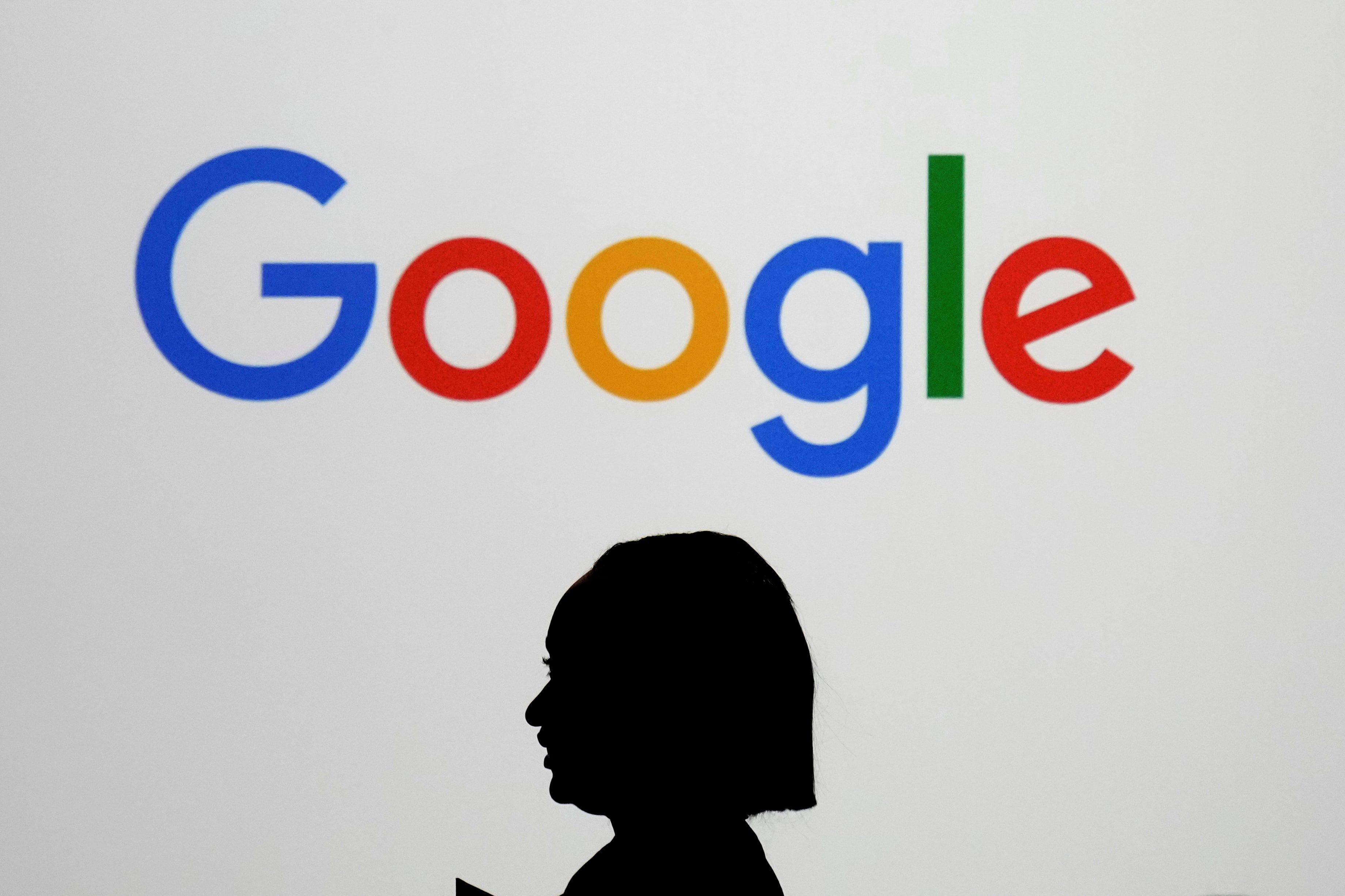 ARCHIVO - Una mujer pasa por delante de una pantalla gigante con el logo de Google en un evento en el Paris Google Lab, durante la AI Action Summit, en París, el 9 de febrero de 2025. (AP Foto/Thibault Camus, archivo)