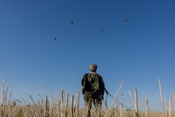 Un militar ucraniano de las Fuerzas de Asalto Aéreo observa el aterrizaje de los paracaidistas durante un entrenamiento de salto en paracaídas en una ubicación no revelada, el 12 de agosto de 2026, en medio de la invasión rusa de Ucrania (Tetiana Dzhafarova/AFP)