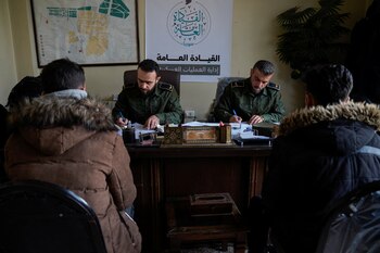 Rebeldes, liderados por el grupo Hayat Tahrir al-Sham, hablan con lo que dicen son miembros de las fuerzas del presidente sirio Bashar al-Assad, en una estación de policía tomada por los rebeldes en Alepo, Siria, después de su asalto relámpago la semana pasada, en Alepo, Siria, el 5 de diciembre de 2024. REUTERS/Karam al-Masri